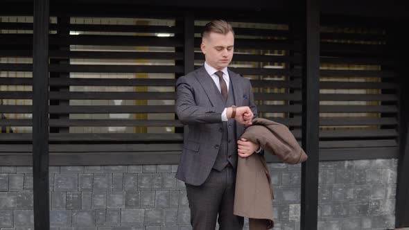 Young Elegant Male Businessman in Brown Suit Near Office Center Waiting for Business Meeting