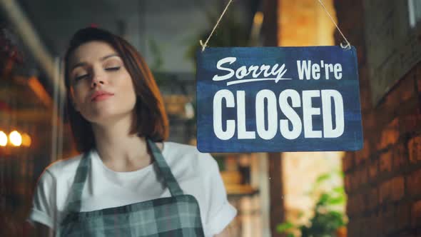 Business Owner Hanging We're Open Sign on Front Door Smiling Welcoming Clients