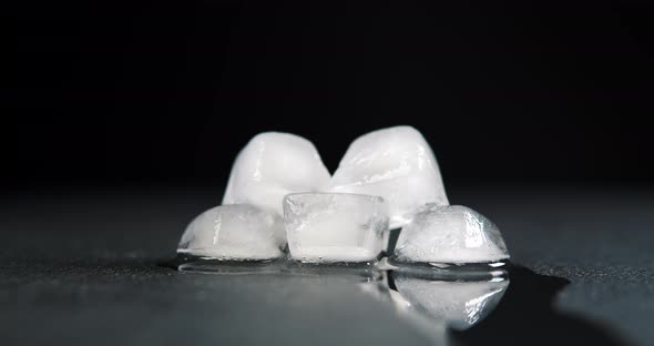 Melting Clear Ice Cube on Black Background  Time Lapse