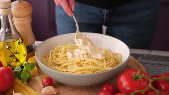 Making Pasta Carbonara  Adding Cream Sauce with Pancetta to Spaghetti in Ceramic Dish