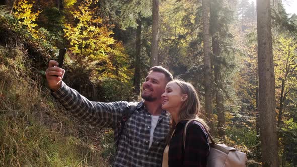Happy People are Taking Selfie By Smartphone in Picturesque Autumn Forest