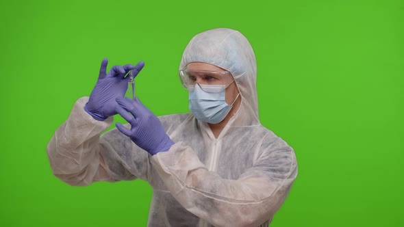 Doctor in PPE Suit with Vaccine Ampoule in Hands Offering Vaccination Against Coronavirus Pandemic