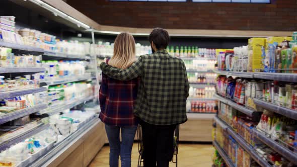 Couple Pushing Shopping Cart in Supermarket Rare View