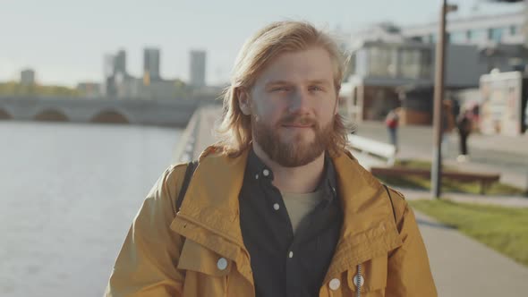 Portrait of Young Man on River Embankment in City