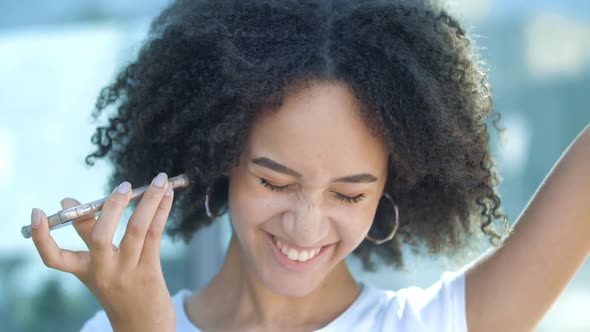 Beautiful African Girl with Makeup Afro Hairstyle is Recording Voice Message on Phone Talking to Her