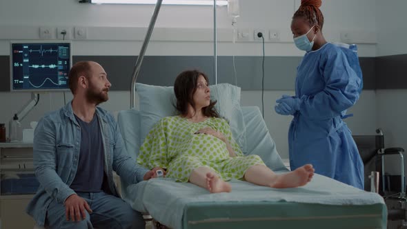 Woman Expecting Child Sitting in Hospital Ward