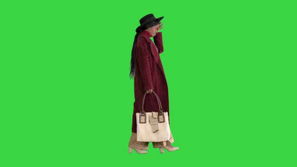 Pretty American Woman in a Hat Walking on a Green Screen, Chroma Key.