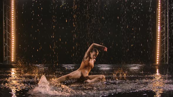 Young Woman Performs Choreography Modern Ballet with Acrobatic Elements Bending Body on Water