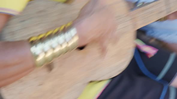 Close-up of an elderly Karen woman playing traditional guitar in local shop in northern Thailand.