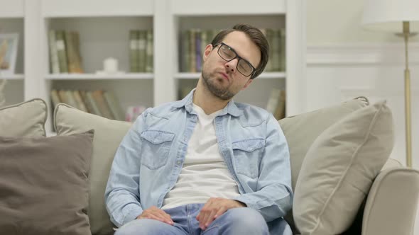 Tired Young Man Sleeping on Sofa