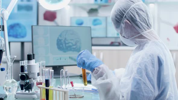 Scientist in White Coverall and Protective Glasses Working with Sample Tubes alt