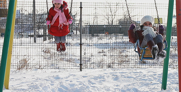 Girls in Swings in Winter Playground