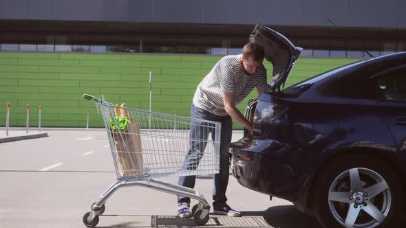 Man with Cart on Shopping Mall Parking