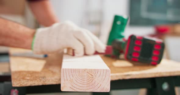 A Bearded Handyman is Sanding Wood for Furniture in a Carpentry Workshop