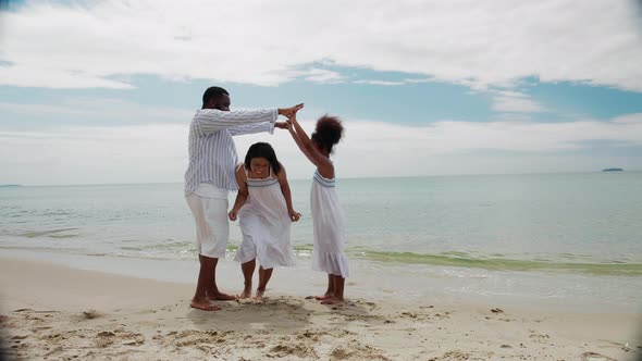 Happy African American family playing together on the tropical beach on vacation
