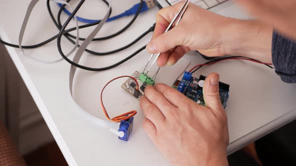Male Programmer Creates Robotics an Arduino Board Controls Servo Motors