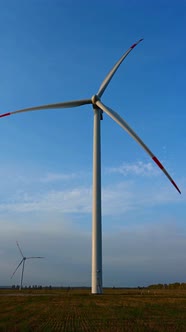 Wind turbine in an offshore wind farm in the green field against low sun on sun