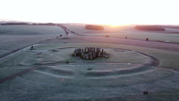 Stonehenge at sunrise panning shot with traffic going past