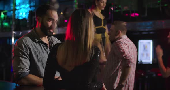 Young Middle Eastern Handsome Man Talking with Unrecognizable Caucasian Woman in Night Club. Joyful