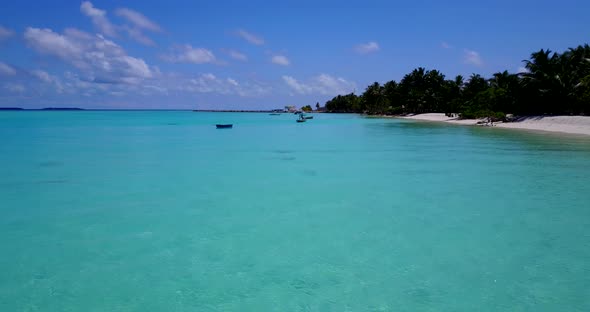 Wide angle birds eye travel shot of a paradise sunny white sand beach and aqua blue water background