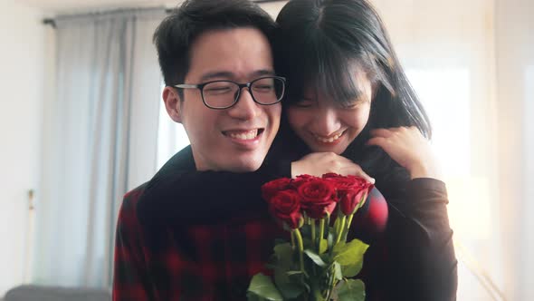 Young Asian Man Giving Red Roses to His Girlfriend