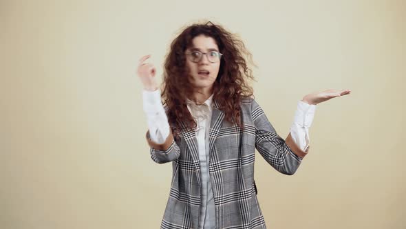 The Beautiful Young Woman with Outstretched Palm Points with Her Index Finger on the Right Side to