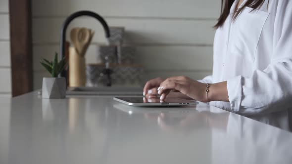 Girl typing text on digital tablet