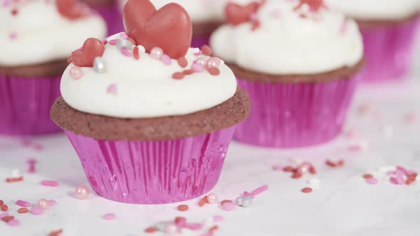 Red velvet cupcakes with cream cheese frosting and decorates with heart and kiss shaped red chocolat