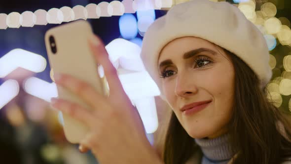 Close up video of woman browsing phone  and drinking mulled wine.  