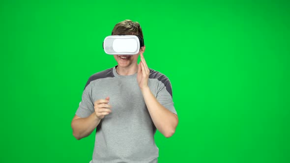 Smiling Man Wearing a Virtual Reality Headset Goes at the Green Screen