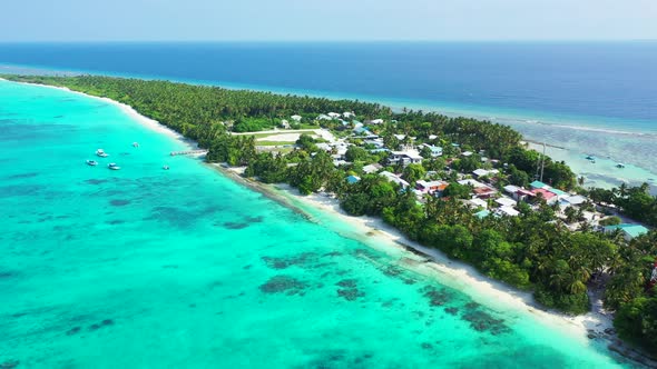 Wide angle drone tourism shot of a paradise sunny white sand beach and blue sea background in colorf