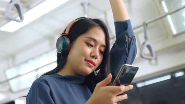 Young Woman Using Mobile Phone on Public Train