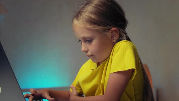 School Child Typing Text on Laptop