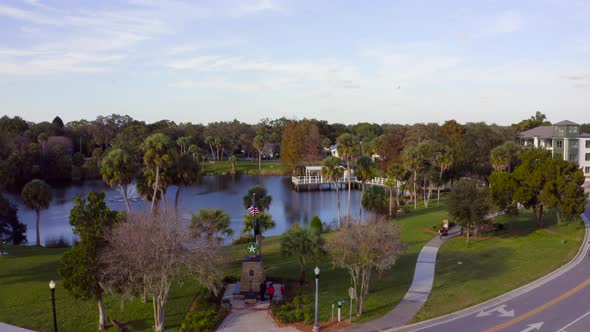 Flying Towards a Pond With a Fountain Surrounded by Trees in New Port Richey