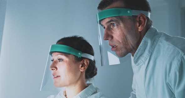 Two researchers in a science lab working on the computer