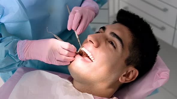 Female Dentist Examining a Patient with Tools in Dental Clinic