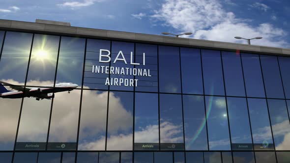 Airplane landing at Bali Indonesia airport mirrored in terminal