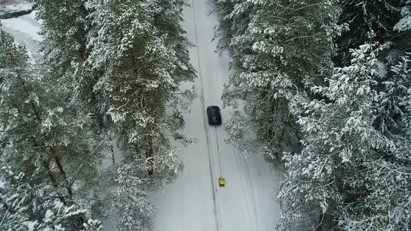 Aerial View of Car Moving in Winter Forest