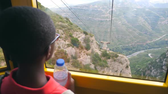 Unrecognizable Black Boy Is Riding a Cable Car and Looking at the Beautiful Nature Landscape