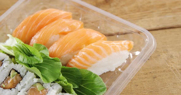 Sushi rolls with salmon in plastic container