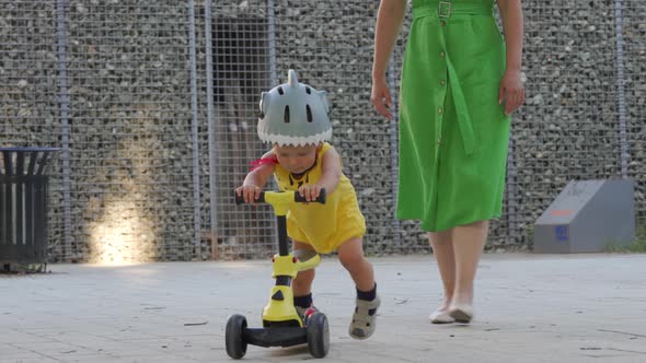 Mother Teaches Her Toddler to Ride Balance Bike for Younger Kids Outdoors 1