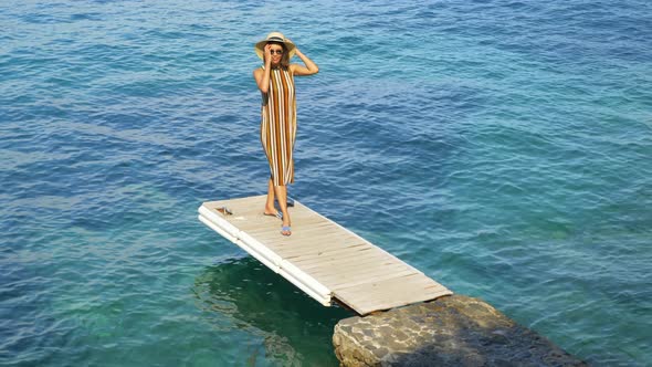 A woman traveling alone on a dock over the Mediterranean Sea in Italy, Europe