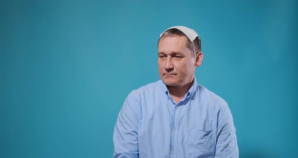 Serious Man with White Disposable Mask on Head Poses Dancing