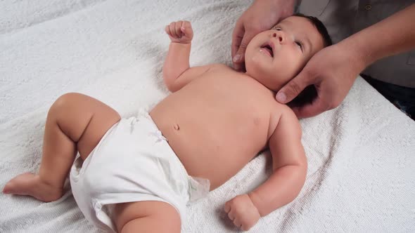 The Masseur Gives a Massage To the Baby. A Child Who Is Being Massaged Is Lying on the Couch. Baby