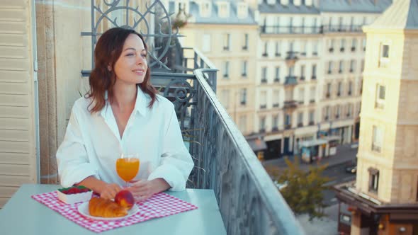 Smiling woman on a balcony in the morning