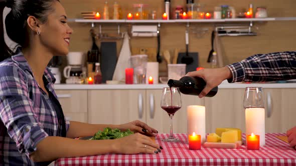 Man Pouring Wine in Glass To His Wife