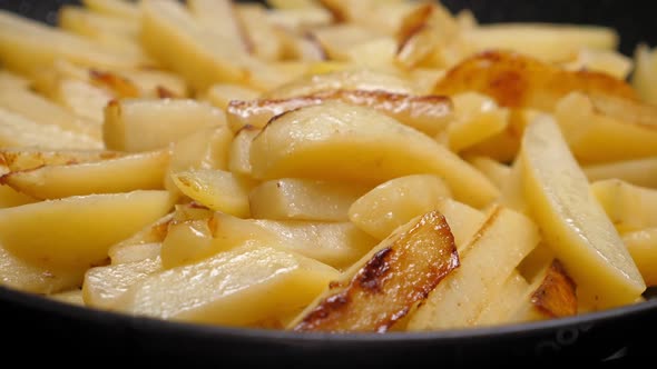 Cooking Fried Potato on Frying Pan. Roasting Sliced Potatoes