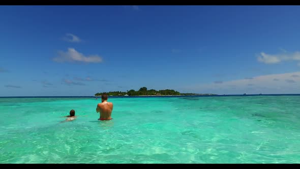 Two people in love on perfect lagoon beach wildlife by blue sea and white sand background of the Mal