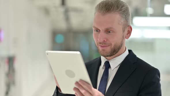 Portrait of Excited Businessman Celebrating Success on Tablet