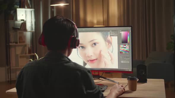 Asian Male Digital Editor Works In Photo Editing Software On His Personal Computer